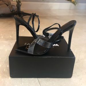 Black stiletto heel with clear strap by toes.